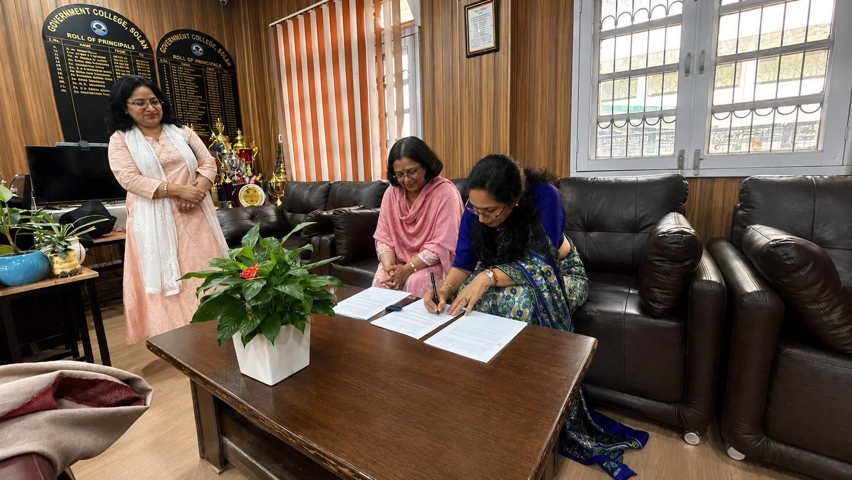 Officials from both institutions review the signed agreement